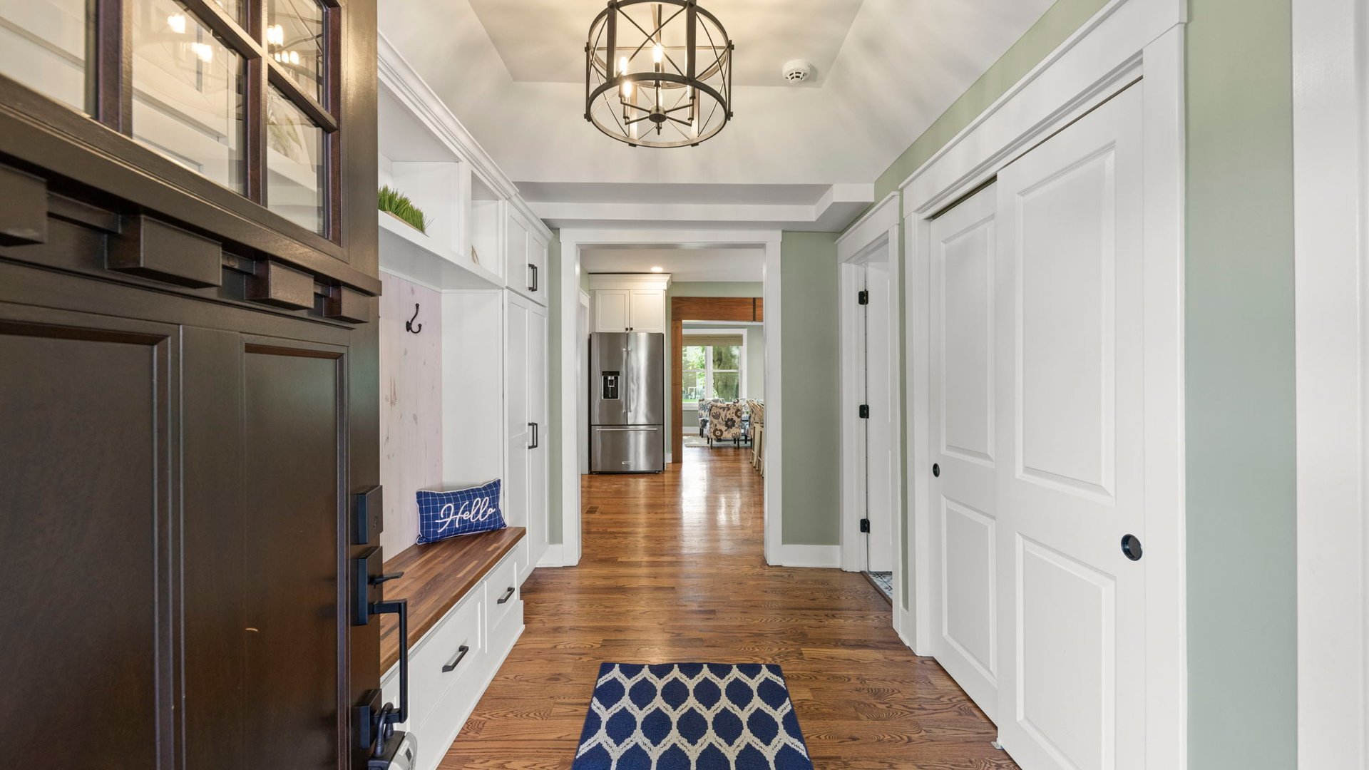 3614 Wolf Road Oswego, IL 60543 - Photo 7 of 56 a hallway with wooden floor and chandelier