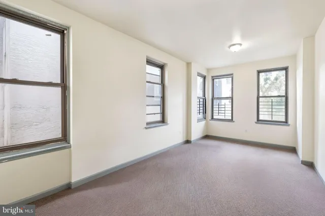 an empty room with windows and closet