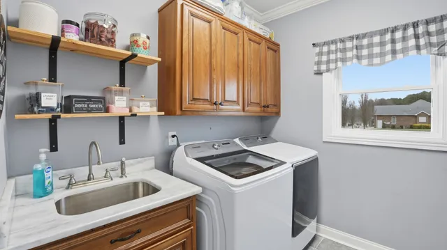 a view of an empty room with a window and hardwood