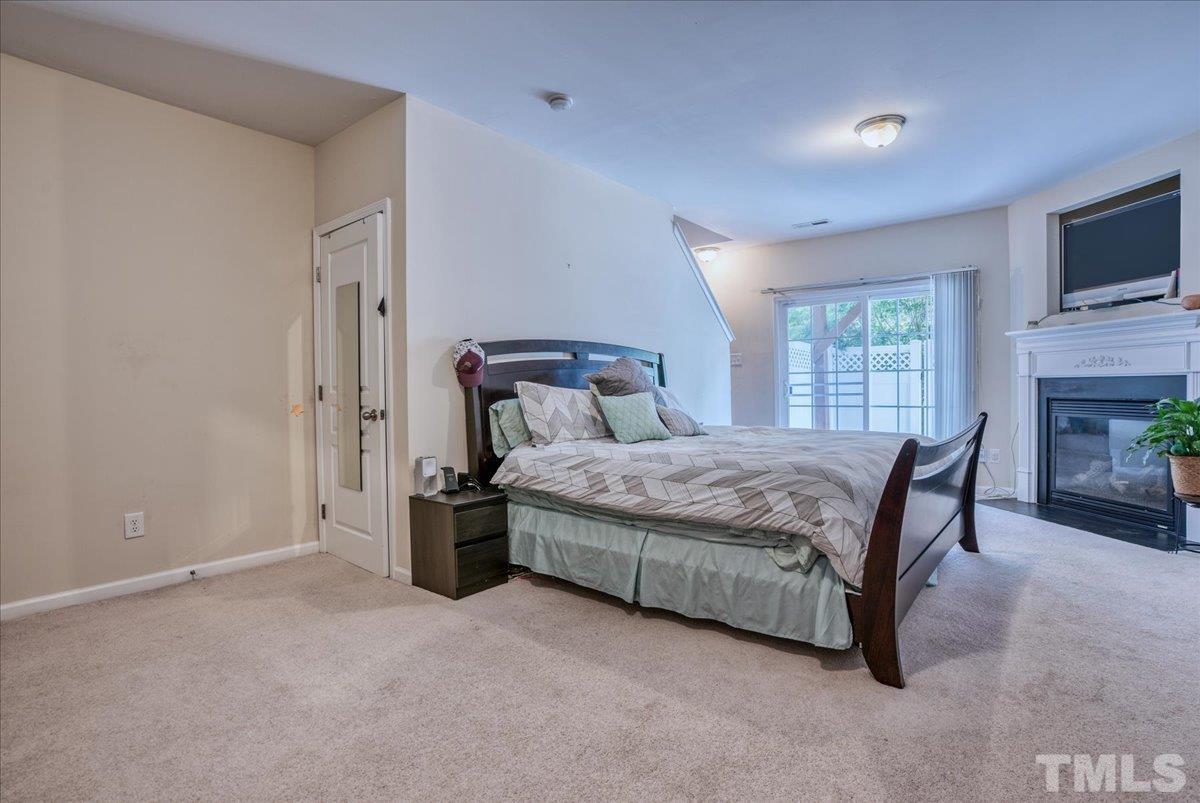7604 Canvas Art Terrace Raleigh, NC 27617 - Photo 15 of 20 a bedroom with a bed a fireplace and a flat tv screen