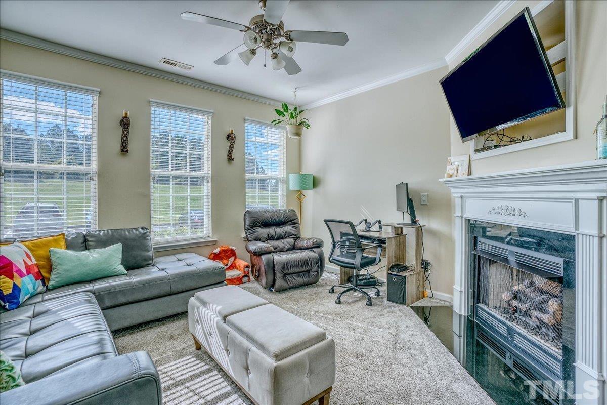 7604 Canvas Art Terrace Raleigh, NC 27617 - Photo 4 of 20 a living room with furniture a flat screen tv and a fireplace