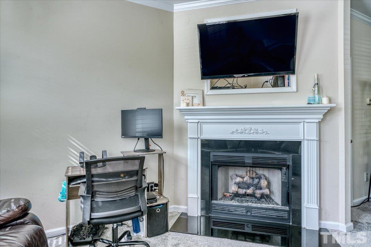 7604 Canvas Art Terrace Raleigh, NC 27617 - Photo 5 of 20 a living room with a fireplace and a flat screen tv