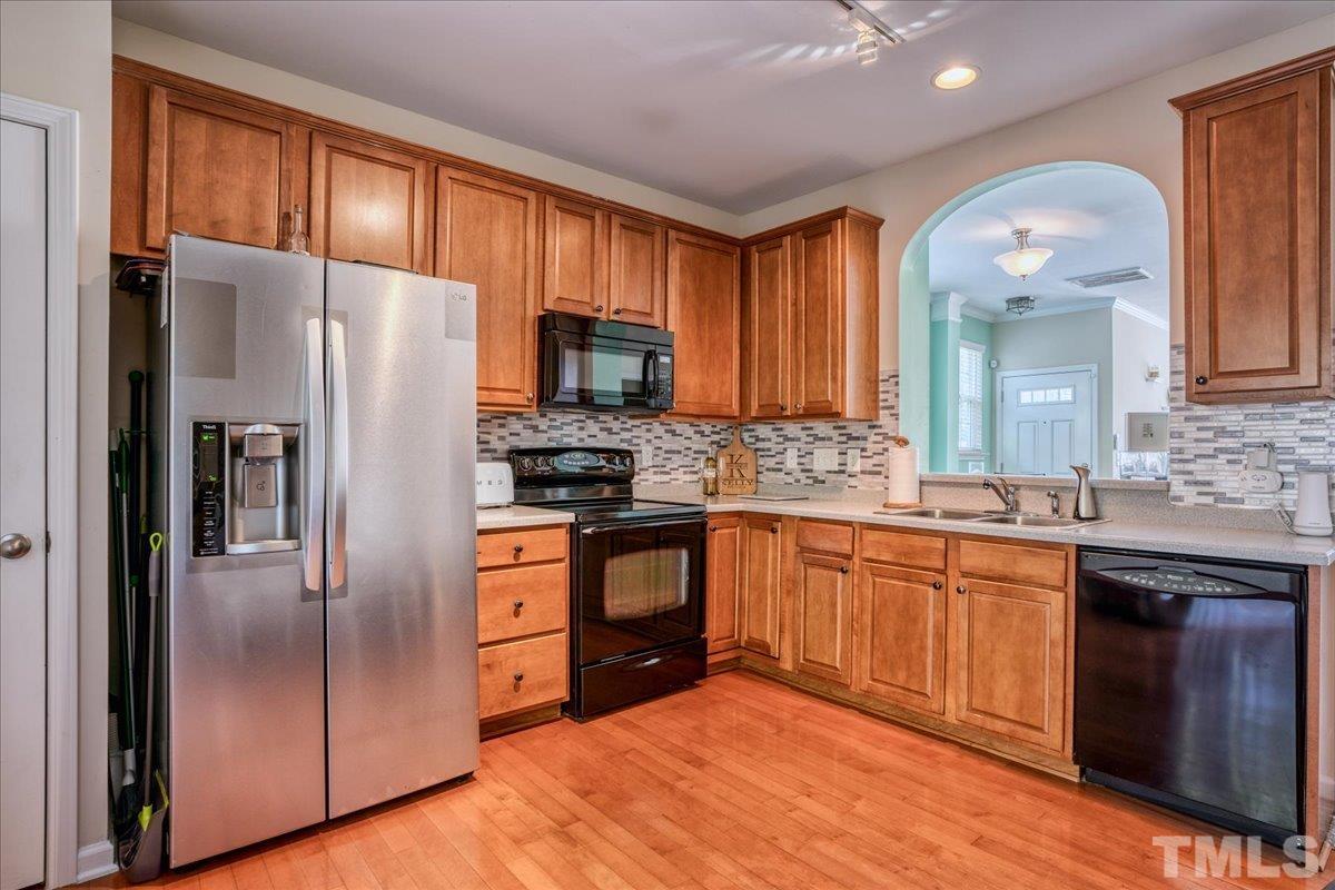 7604 Canvas Art Terrace Raleigh, NC 27617 - Photo 7 of 20 a kitchen with stainless steel appliances granite countertop a refrigerator a sink dishwasher a stove with wooden cabinets and floor