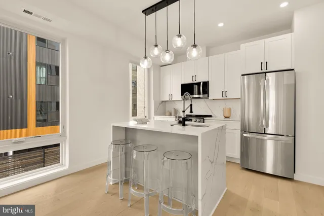 a kitchen with granite countertop cabinets stainless steel appliances and a window