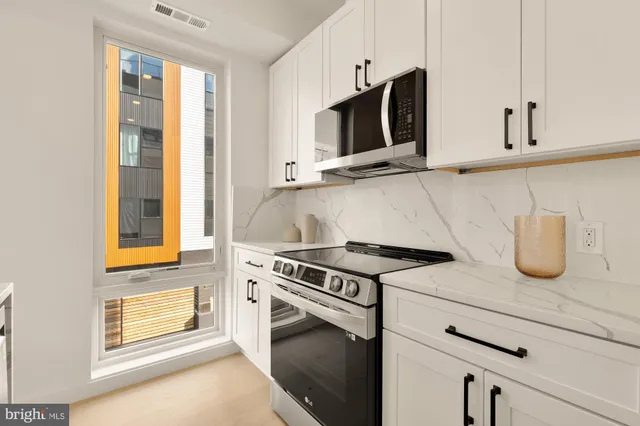 a kitchen with stainless steel appliances kitchen island a sink stove and microwave