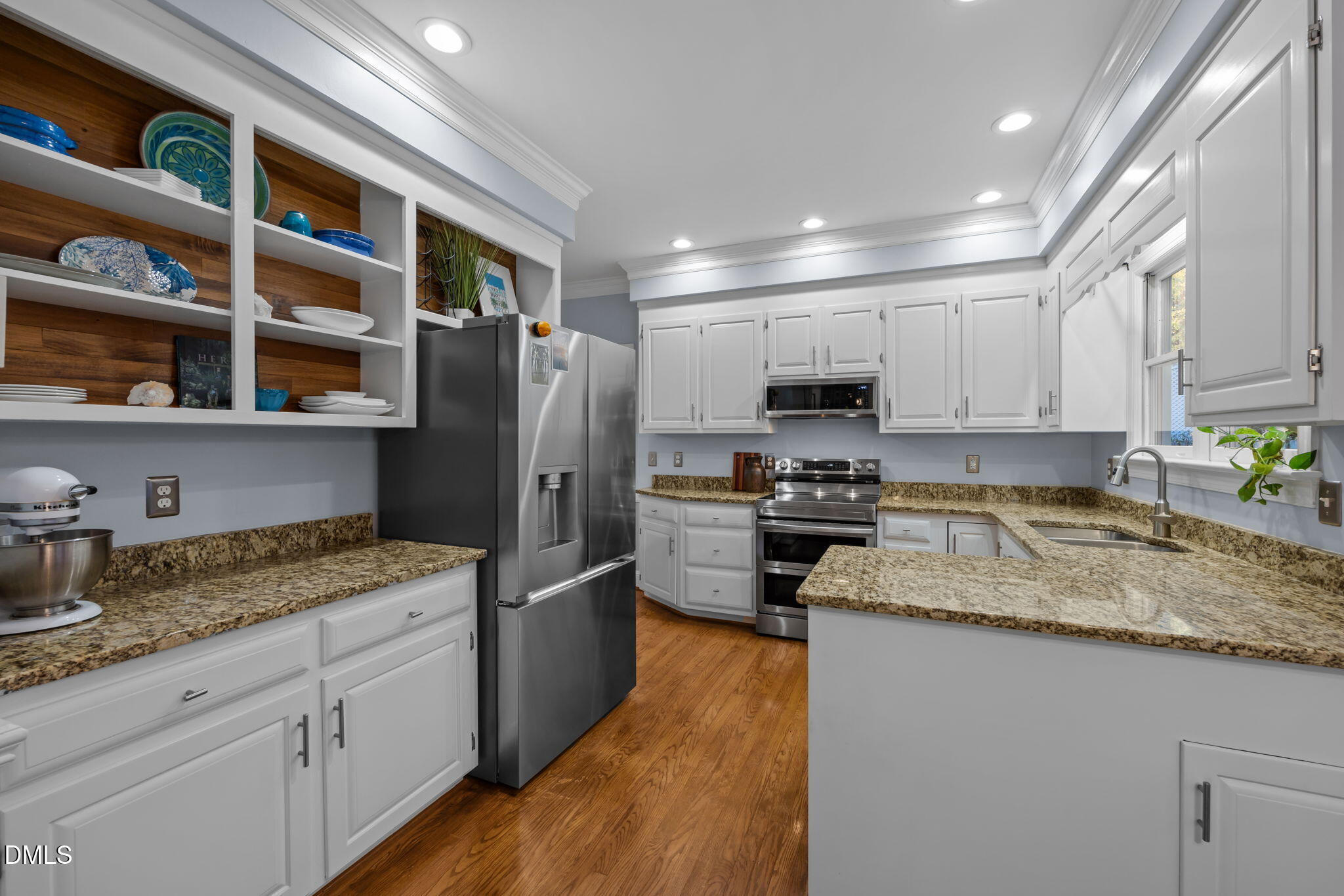 4304 Omni Place Raleigh, NC 27613 - Photo 16 of 58 a kitchen with granite countertop stainless steel appliances a refrigerator cabinets and wooden floor
