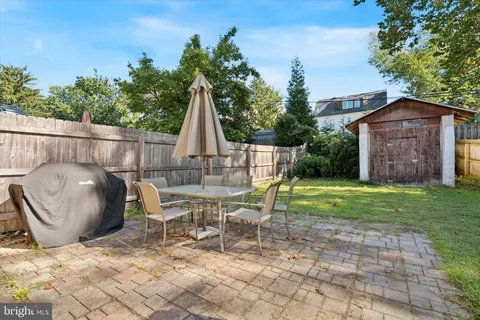 a view of a chair and table in backyard of the house