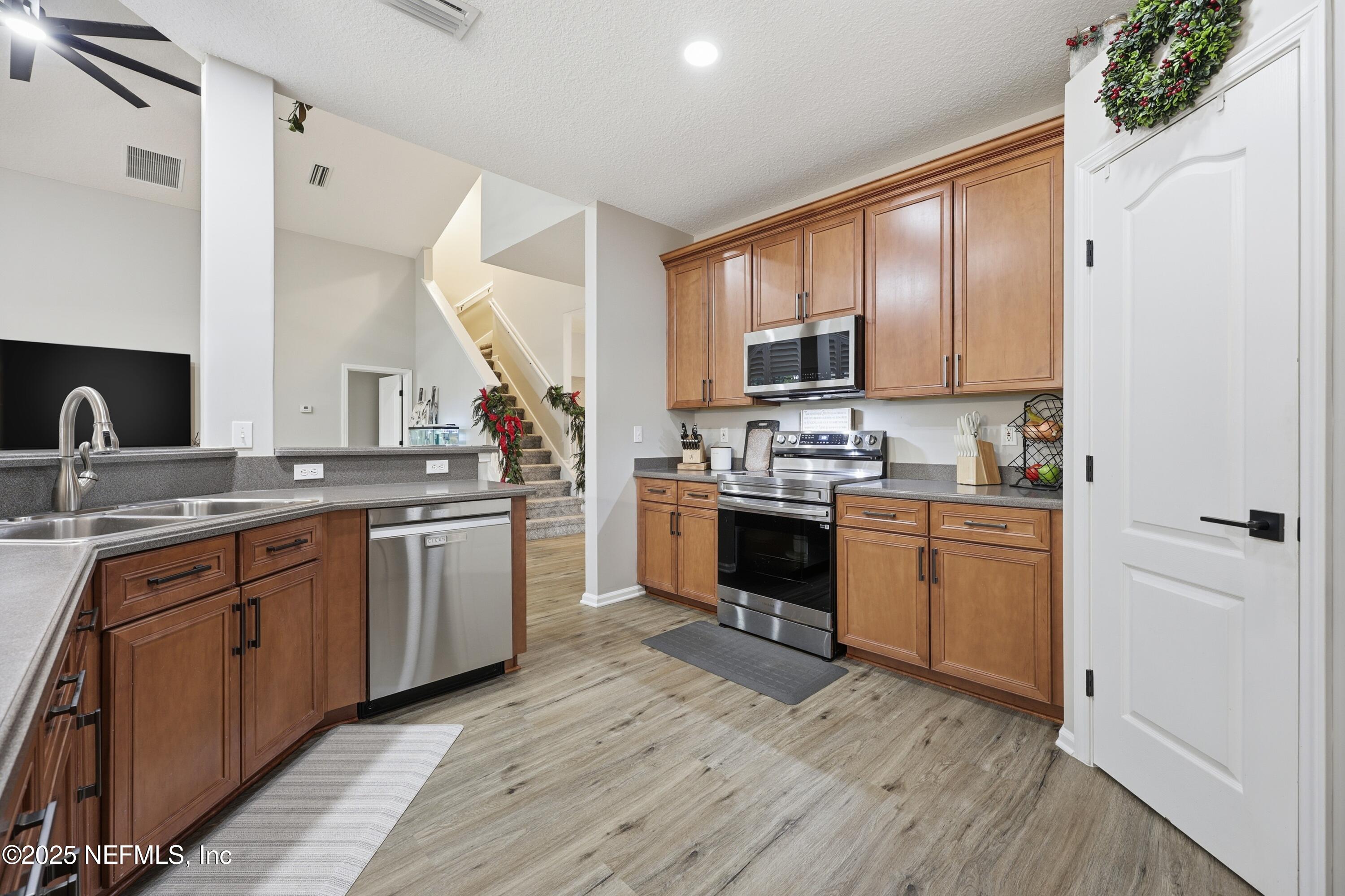 2301 Country Side Drive Fleming Island, FL 32003 - Photo 19 of 58 a kitchen with stainless steel appliances granite countertop a stove sink and cabinets