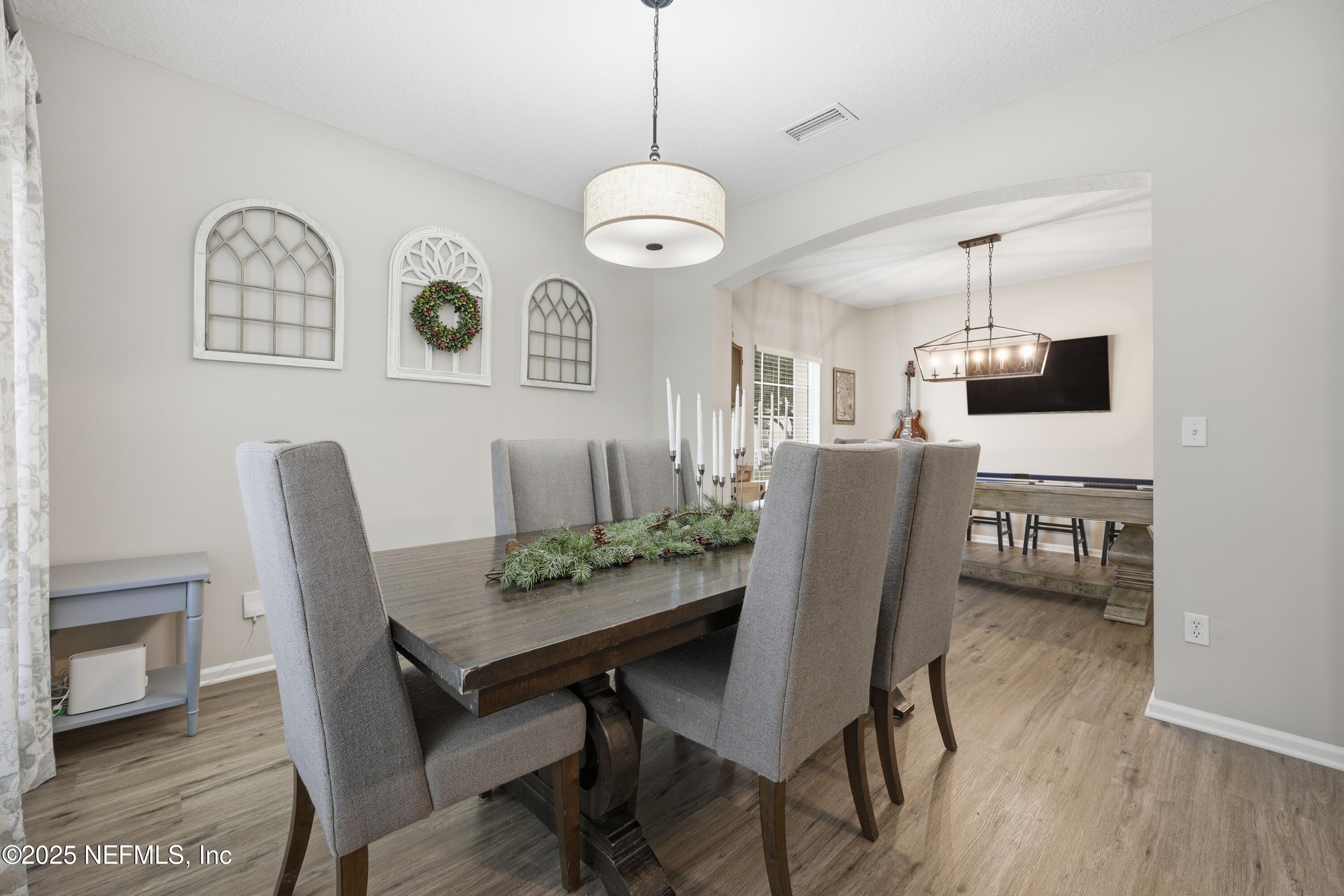 2301 Country Side Drive Fleming Island, FL 32003 - Photo 7 of 58 a view of a dining room with furniture and wooden floor