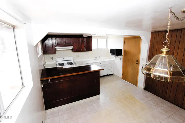 a living room with stainless steel appliances kitchen island a stove and a refrigerator