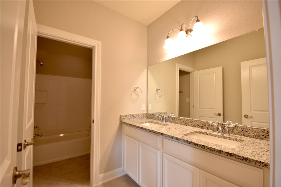15911 Cessida Street Austin, TX 78728 - Photo 19 of 22 This 2nd Bath Upstairs Features Granite Counters, Two Rectangle Undermount Sinks and Two Separate Spaces So Someone Could Be Using the Tub Area at the Same Time Someone Is Using A Sink