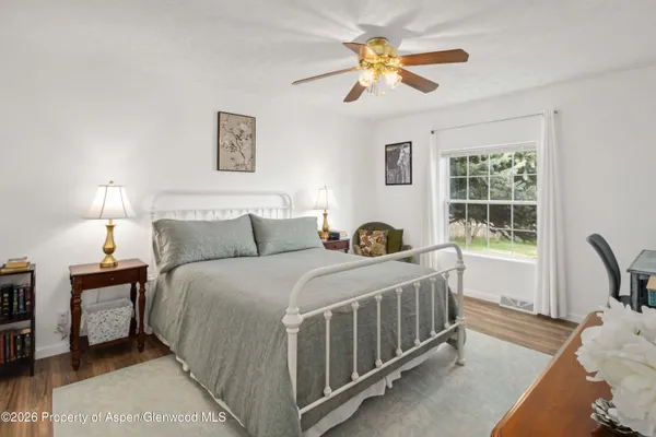 a bedroom with a bed a chandelier and a window