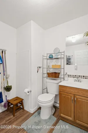 a spacious bathroom with a toilet a sink and a mirror