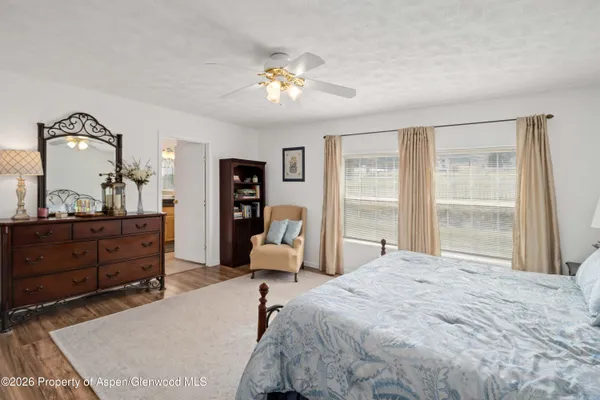 a bedroom with a bed and large windows