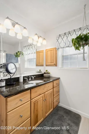 a bathroom with a granite countertop sink and a mirror