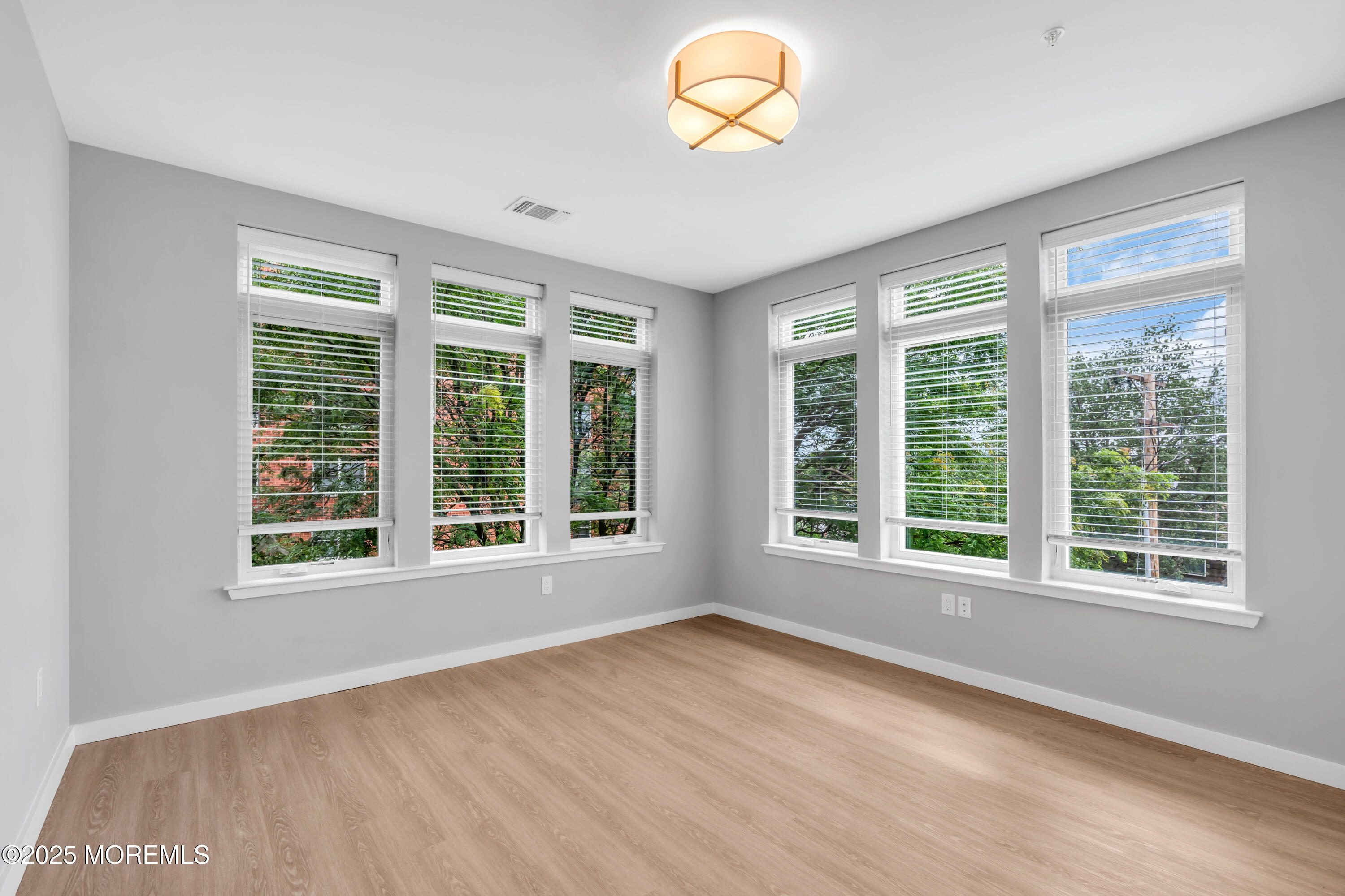120 Monmouth Street, Unit RIVERS EDGE 307 Red Bank, NJ 07701 - Photo 22 of 38 an empty room with wooden floor and windows