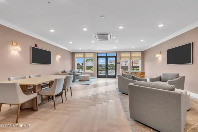 a living room with furniture a flat screen tv and a floor to ceiling window