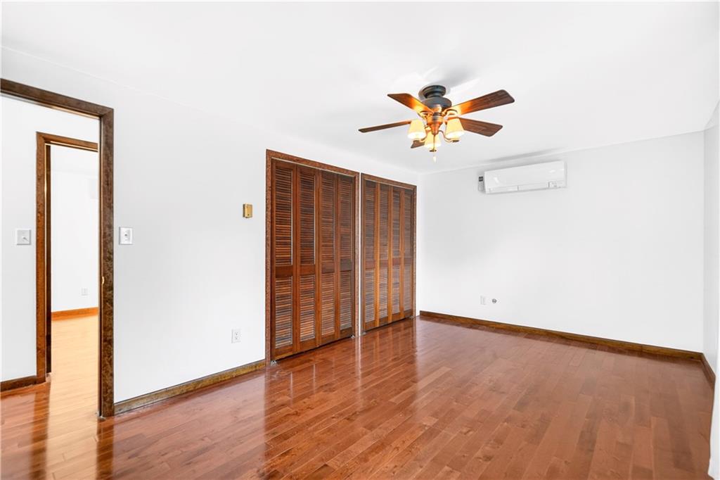 709 Vernon Drive Rostraver Township, PA 15012 - Photo 23 of 40 an empty room with wooden floor and a ceiling fan