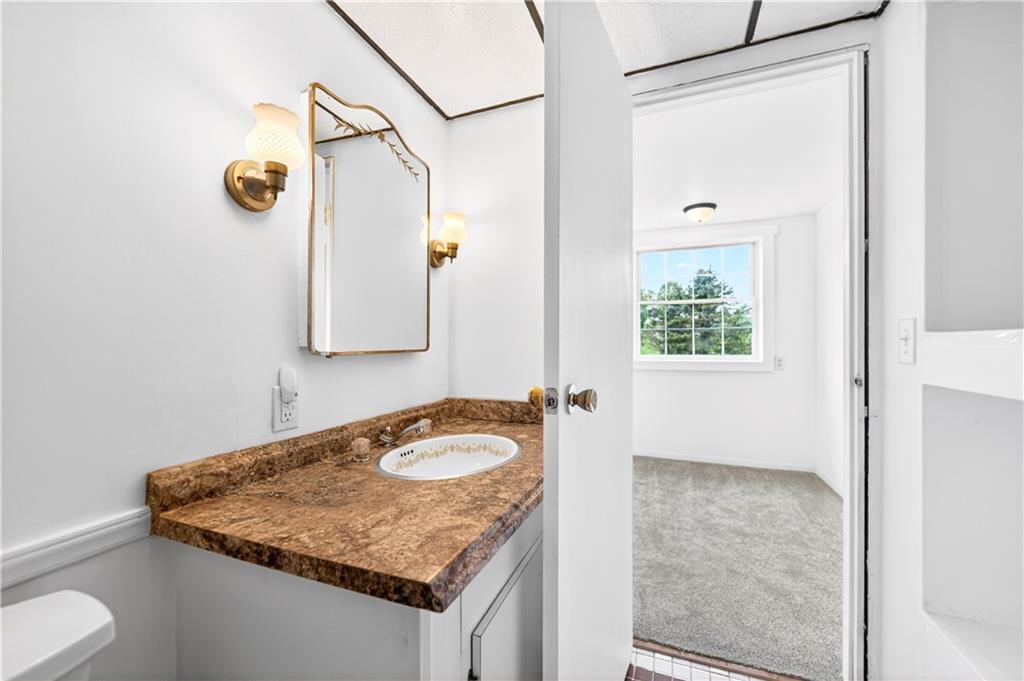 709 Vernon Drive Rostraver Township, PA 15012 - Photo 31 of 40 a bathroom with a granite countertop sink and a mirror