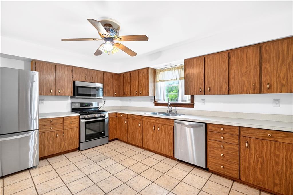 709 Vernon Drive Rostraver Township, PA 15012 - Photo 8 of 40 a kitchen with stainless steel appliances granite countertop a sink a stove a refrigerator with island with cabinets and wooden floor