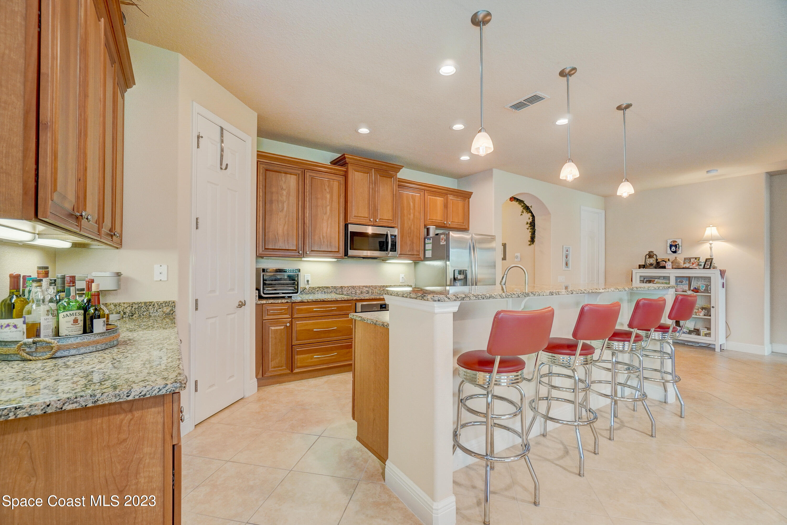 1568 Outrigger Circle Rockledge, FL 32955 - Photo 11 of 44 a large kitchen with kitchen island granite countertop lots of white cabinets a sink and stainless steel appliances