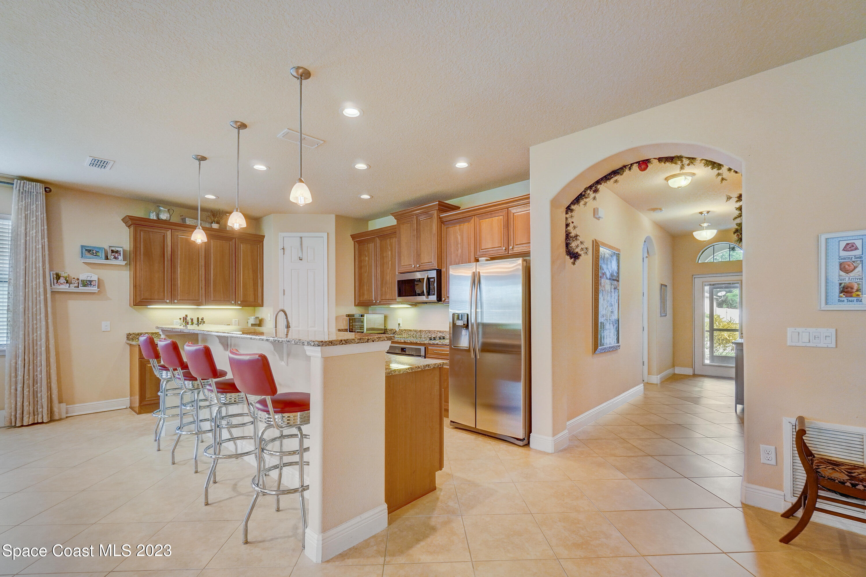 1568 Outrigger Circle Rockledge, FL 32955 - Photo 12 of 44 a kitchen with stainless steel appliances kitchen island granite countertop a refrigerator and a sink