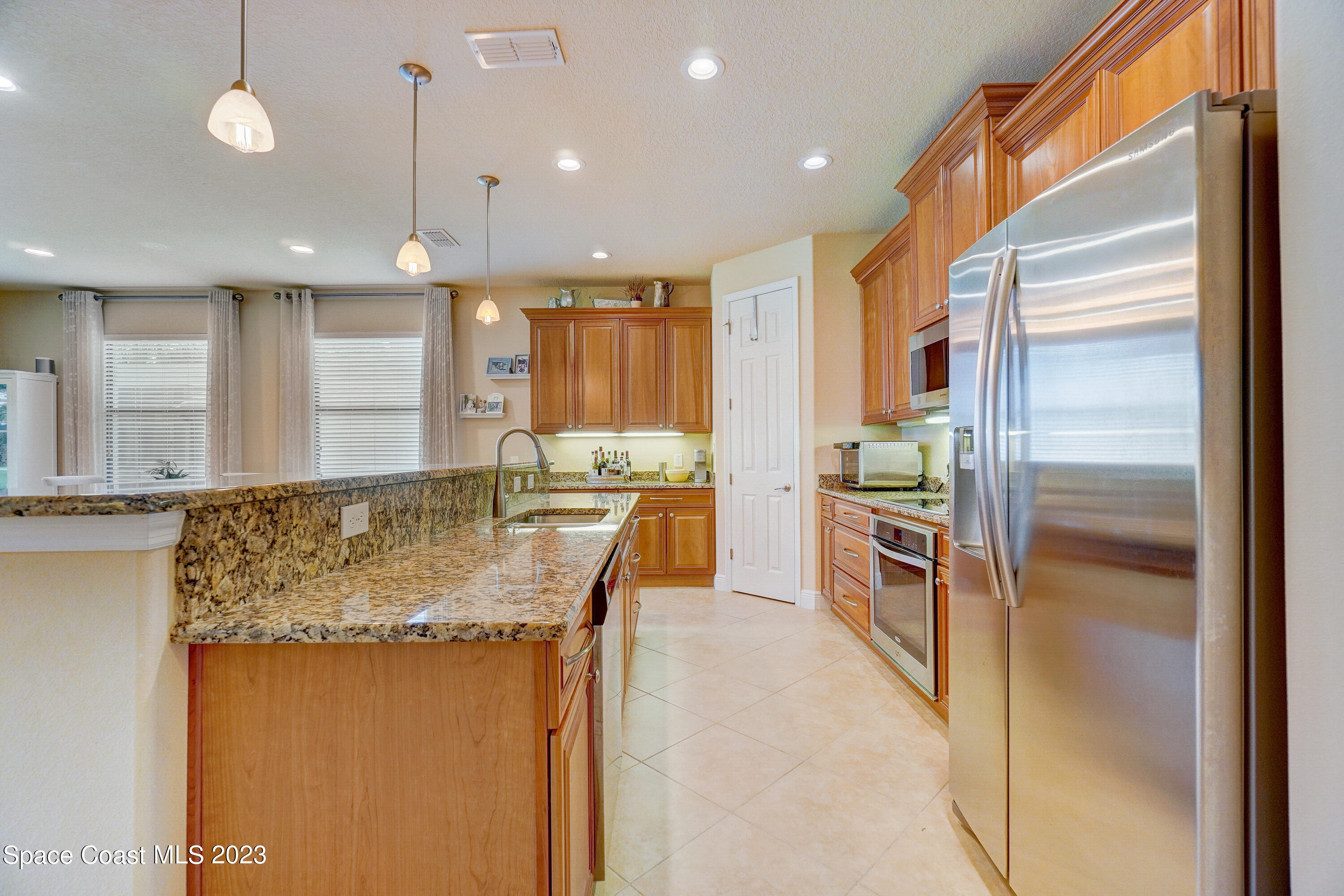 1568 Outrigger Circle Rockledge, FL 32955 - Photo 13 of 44 a kitchen with stainless steel appliances granite countertop sink refrigerator and microwave
