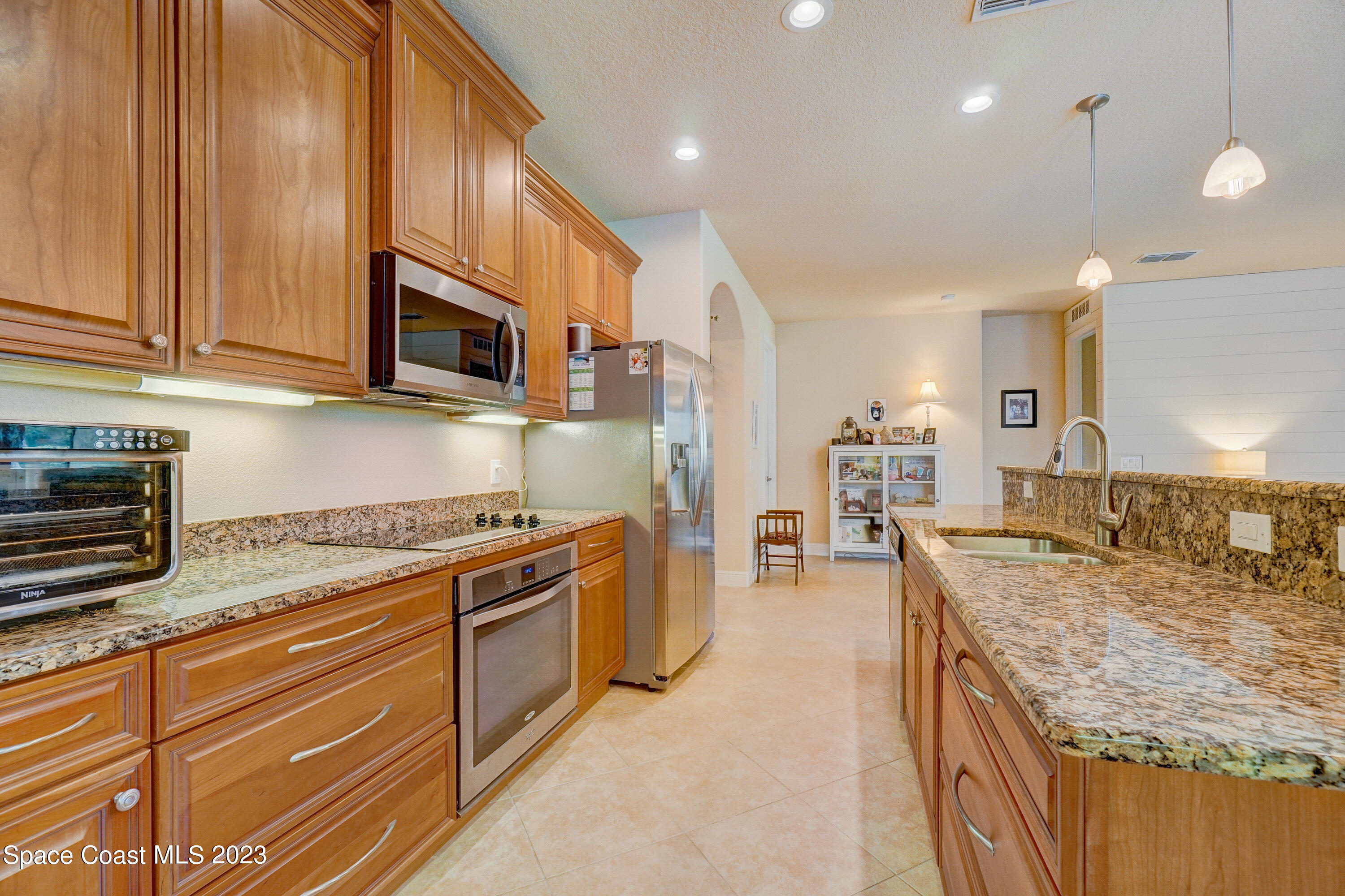 1568 Outrigger Circle Rockledge, FL 32955 - Photo 14 of 44 a kitchen with stainless steel appliances granite countertop a stove a sink and a microwave