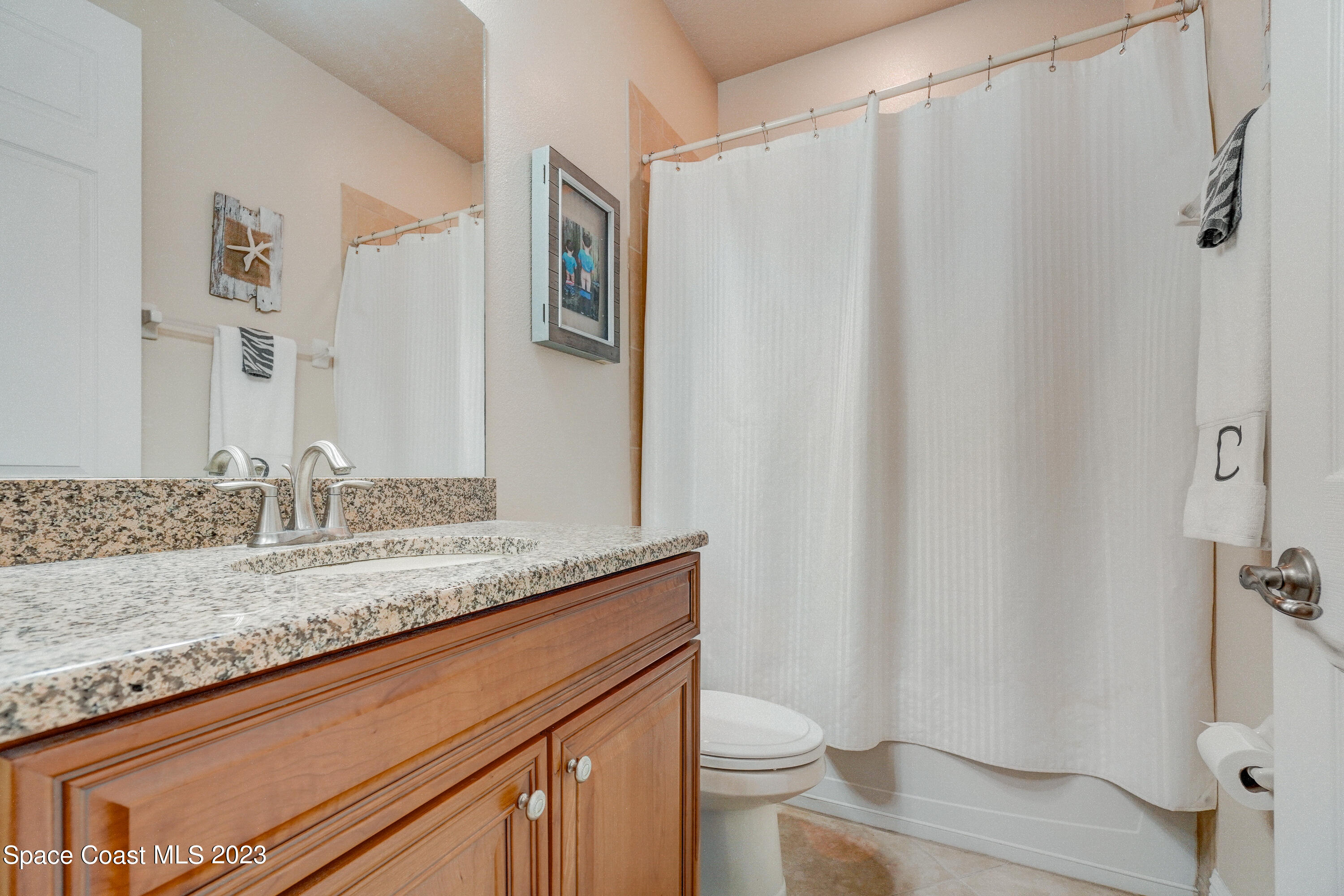 1568 Outrigger Circle Rockledge, FL 32955 - Photo 19 of 44 a bathroom with a granite countertop sink and a mirror