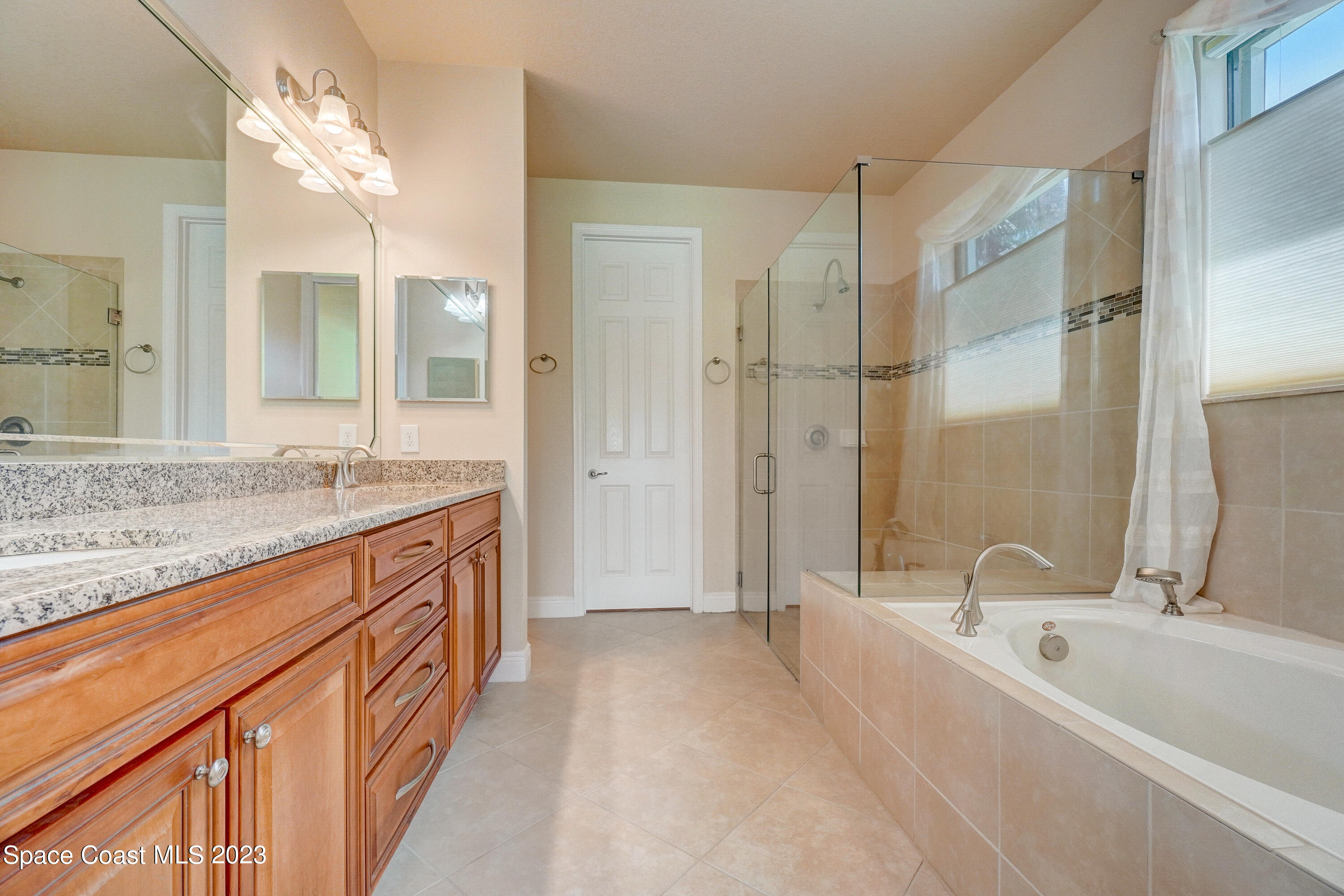 1568 Outrigger Circle Rockledge, FL 32955 - Photo 26 of 44 a spacious bathroom with a granite countertop tub sink shower and mirror
