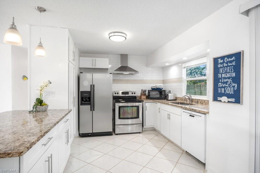 1207 Hernando Street Naples, FL 34103 - Photo 8 of 37 a kitchen with granite countertop white cabinets and white appliances
