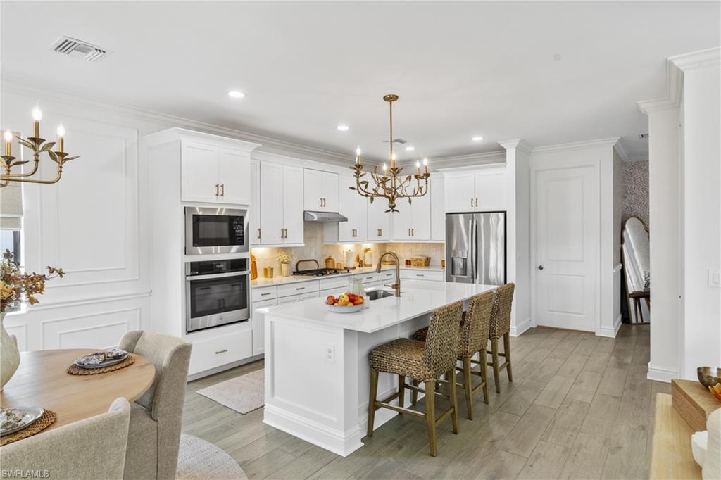 20507 Napa Loop Estero, FL 33928 - Photo 11 of 49 a kitchen with stainless steel appliances a table chairs and refrigerator
