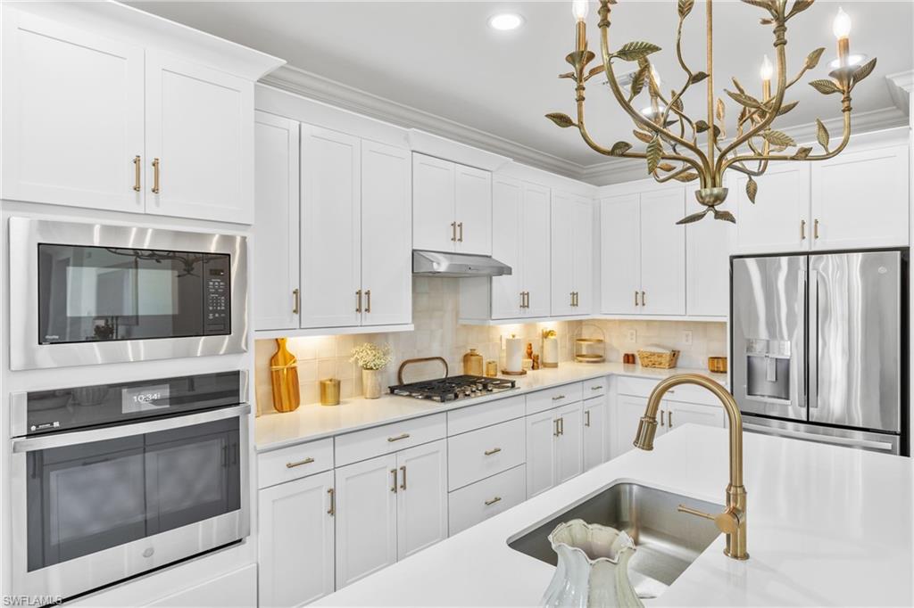 20507 Napa Loop Estero, FL 33928 - Photo 12 of 49 a kitchen with stainless steel appliances granite countertop a sink a stove and cabinets