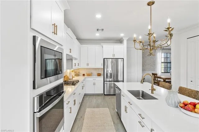 a kitchen with a refrigerator a stove a sink dishwasher a oven with a dining table and chairs