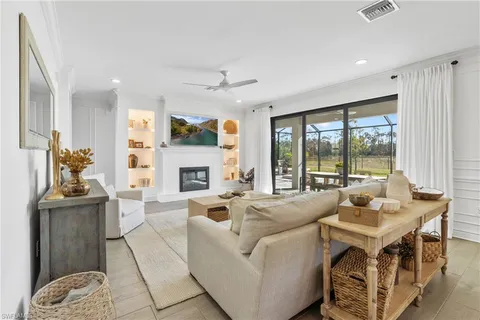 a living room with fireplace furniture and a large window