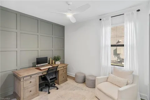 a view of a workspace with furniture and a window
