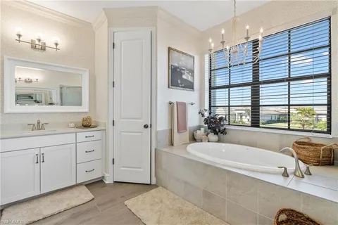 a spacious bathroom with a tub sink and mirror