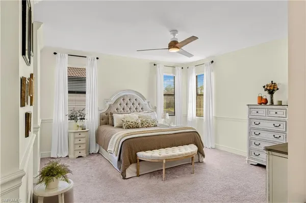 a bedroom with a bed a chandelier and a window