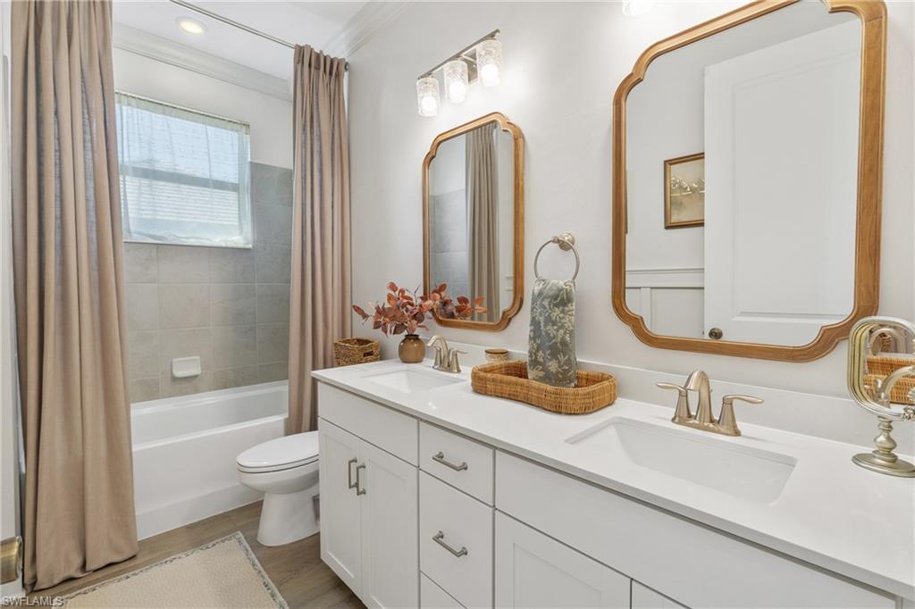 20507 Napa Loop Estero, FL 33928 - Photo 38 of 49 a bathroom with double vanity sinks a toilet and a large mirror