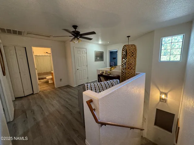 a view of a livingroom with furniture a ceiling fan and windows