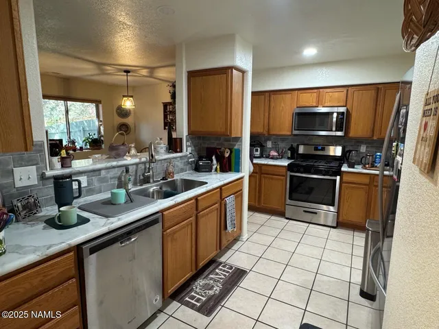 a kitchen with stainless steel appliances a sink stove refrigerator and cabinets