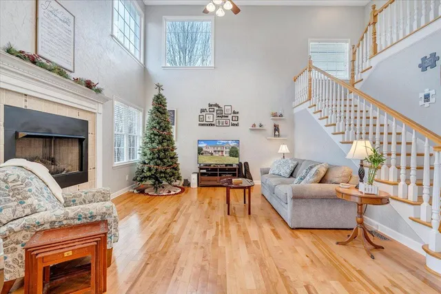 a living room with furniture a wooden floor and next to a window