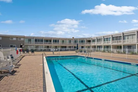 a view of a swimming pool in the backyard of house along with seating space