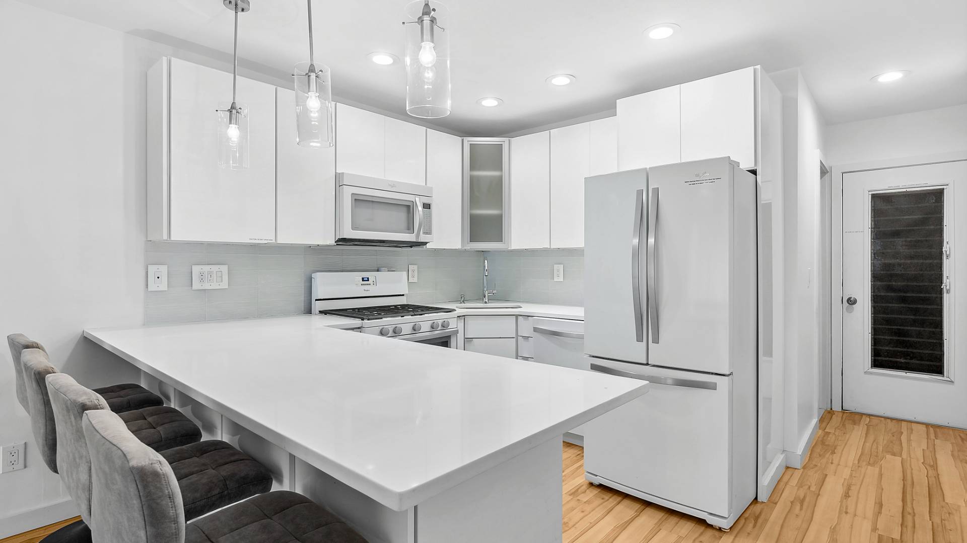 585 Dune Road Westhampton, NY 11978 - Photo 7 of 16 a kitchen with stainless steel appliances granite countertop a refrigerator a sink dishwasher a stove and white cabinets with wooden floor