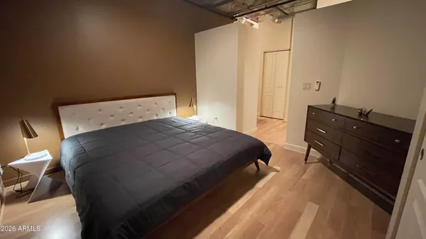 a bedroom with a bed and wooden floor