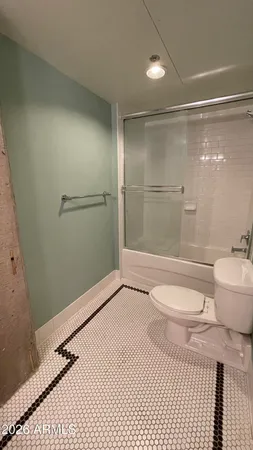 a bathroom with a granite countertop shower and a toilet