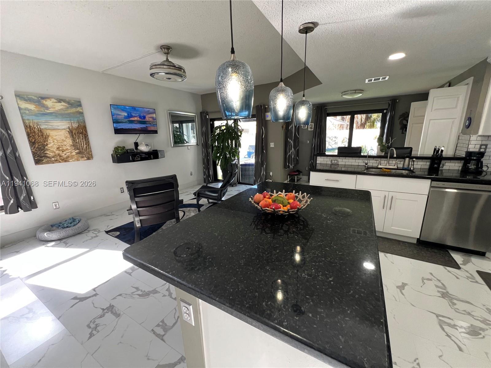 8618 Southwest 161st Place Miami, FL 33193 - Photo 9 of 33 a kitchen with a sink a counter top space and living room view