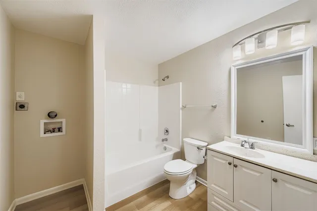 a bathroom with a toilet a sink a mirror and a bathtub