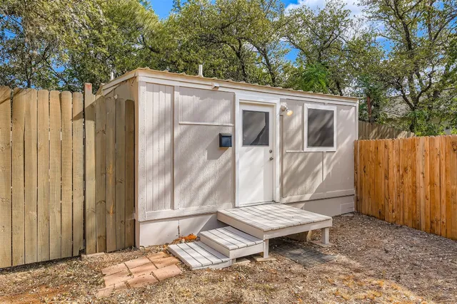 a backyard of a house with a table and chairs