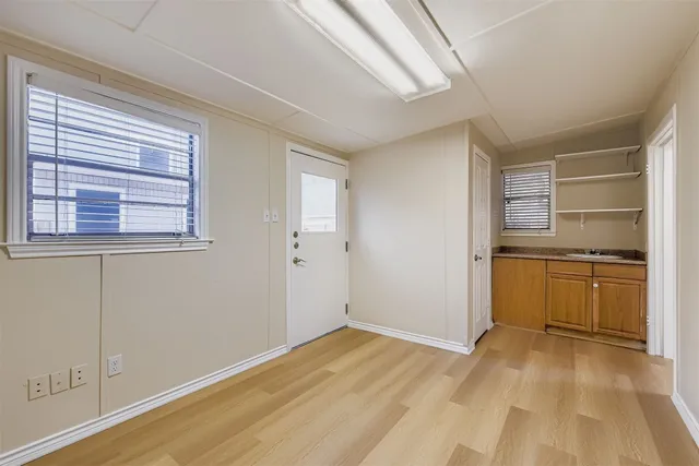 a view of a kitchen with wooden floor and electronic appliances